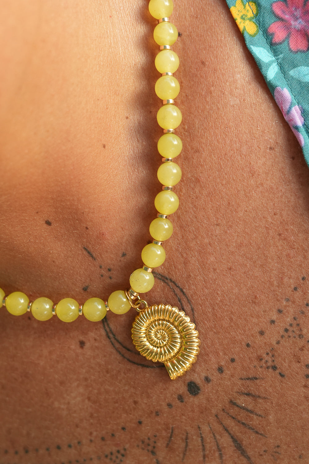 Shop the Ammonite Necklace in Solar Jade Gold, with natural yellow stone beads and a sculpted gold spiral shell pendant from Earth Altering by Jinx the Label.