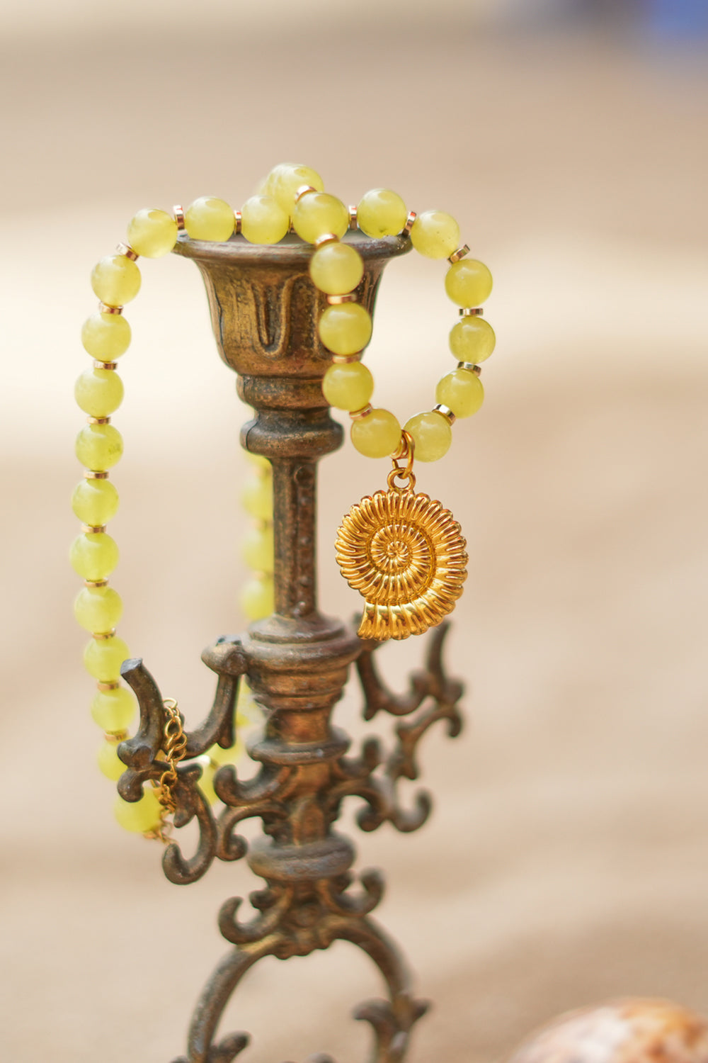 Shop the Ammonite Necklace in Solar Jade Gold, with natural yellow stone beads and a sculpted gold spiral shell pendant from Earth Altering by Jinx the Label.
