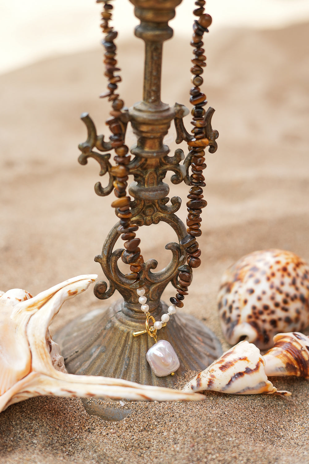 Discover the Desert Soul Necklace in Tiger’s Eye, featuring earthy natural stone chips, freshwater pearls, a gold toggle and luminous baroque pearl by Jinx the Label.