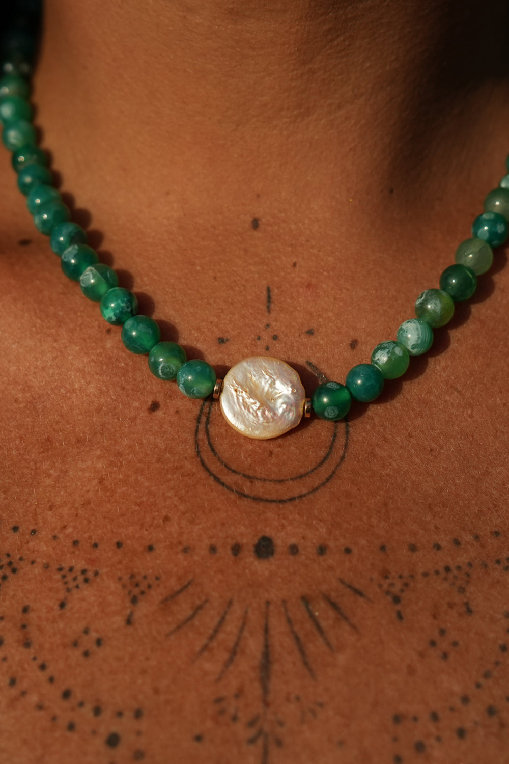 Shop the Gaia Pearl Necklace in Forest Agate, featuring green natural stone beads, an organic statement pearl and delicate gold toned details by Jinx the Label.