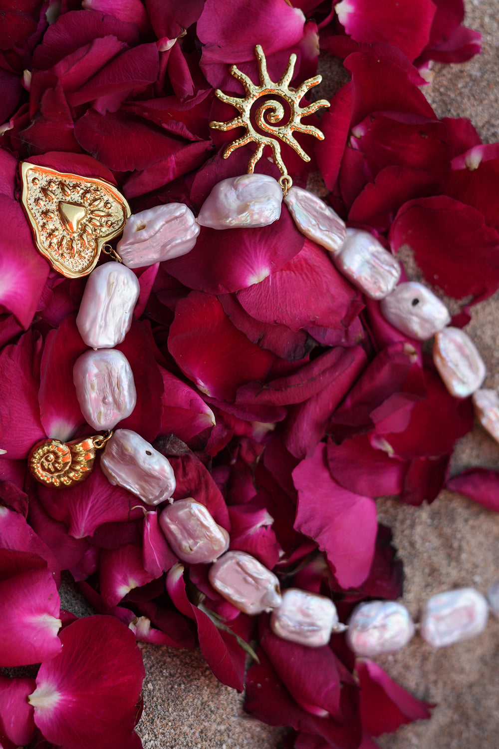 Discover the Sacred Love Necklace in Blush Pearl, featuring irregular freshwater pearls and gold sacred heart, sun and spiral charms by Jinx the Label.