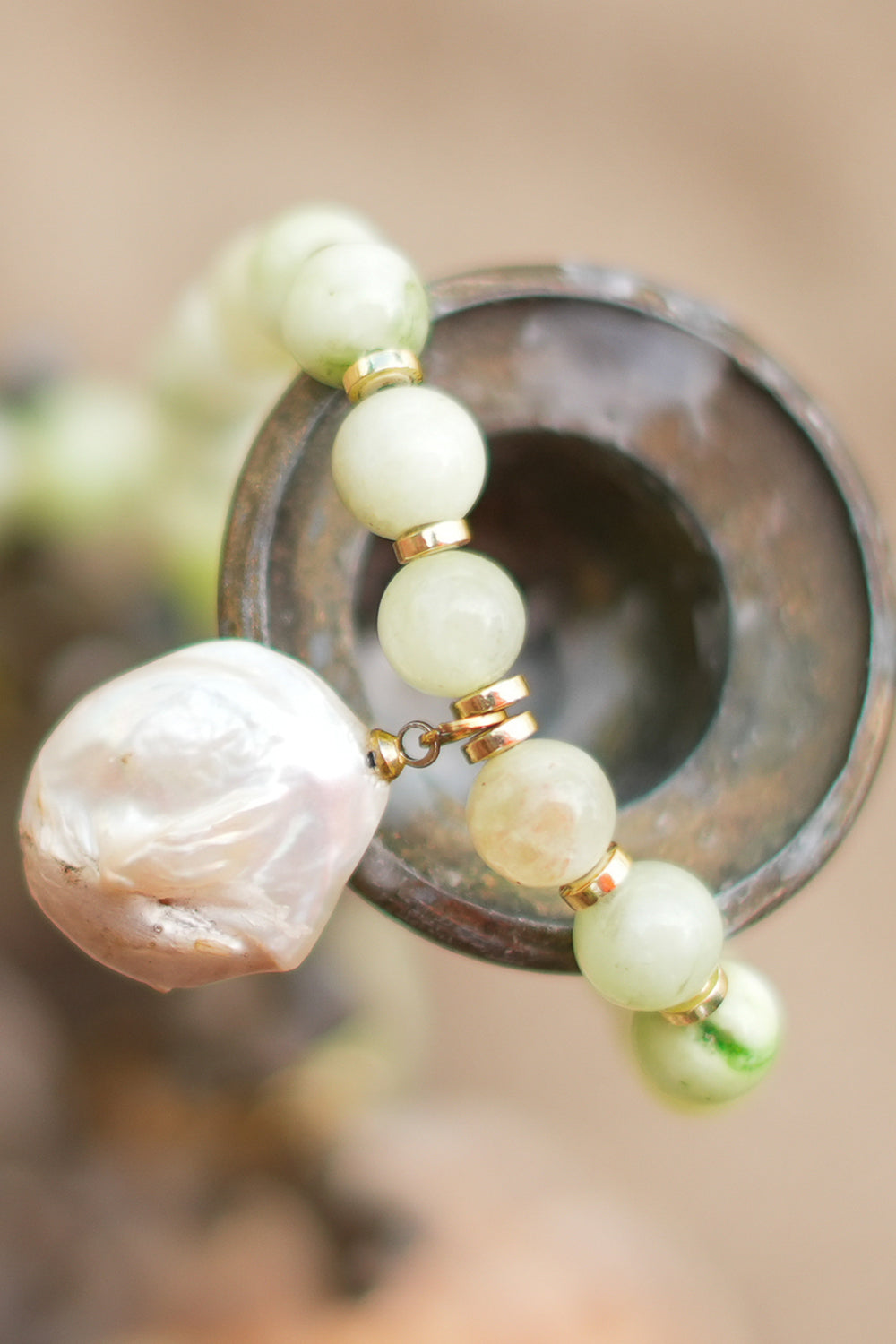 Discover the Sea Garden Necklace in Seafoam, featuring pale green natural stones, gold toned details and an oversized baroque pearl pendant by Jinx the Label.