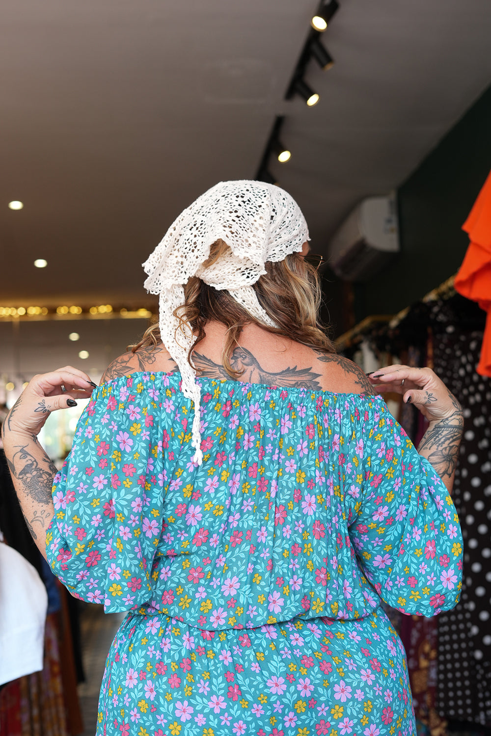 Meet the Dainty Dress in Aqua Bloom, a flowing rayon maxi with an adjustable off-shoulder neckline, elastic waist, tiered skirt and pockets. Handmade in Bali.