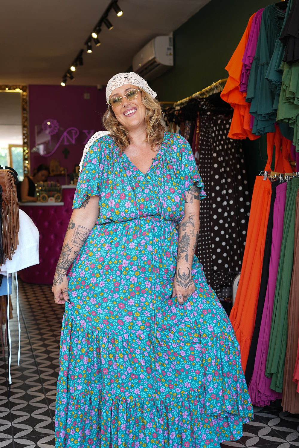 Meet the Dainty Dress in Aqua Bloom, a flowing rayon maxi with an adjustable off-shoulder neckline, elastic waist, tiered skirt and pockets. Handmade in Bali.