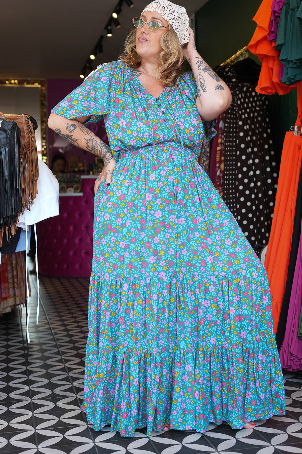 Meet the Dainty Dress in Aqua Bloom, a flowing rayon maxi with an adjustable off-shoulder neckline, elastic waist, tiered skirt and pockets. Handmade in Bali.