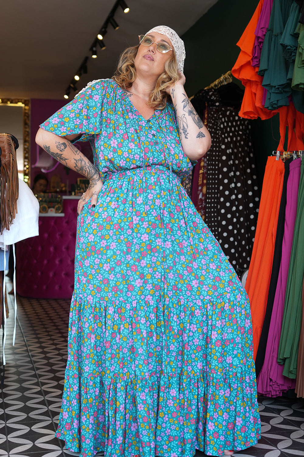 Meet the Dainty Dress in Aqua Bloom, a flowing rayon maxi with an adjustable off-shoulder neckline, elastic waist, tiered skirt and pockets. Handmade in Bali.