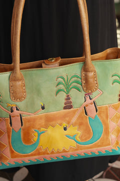 Meet the Desert Siren Tote in Sage and Caramel. A handcrafted leather tote with hand tooled motives artwork, long handles and practical interior compartments.