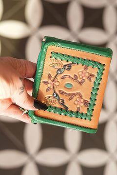 Meet the Freebird Mini Wallet in Cactus Green, a handcrafted leather wallet with hummingbird artwork, woven detailing, turquoise accent and card compartments.