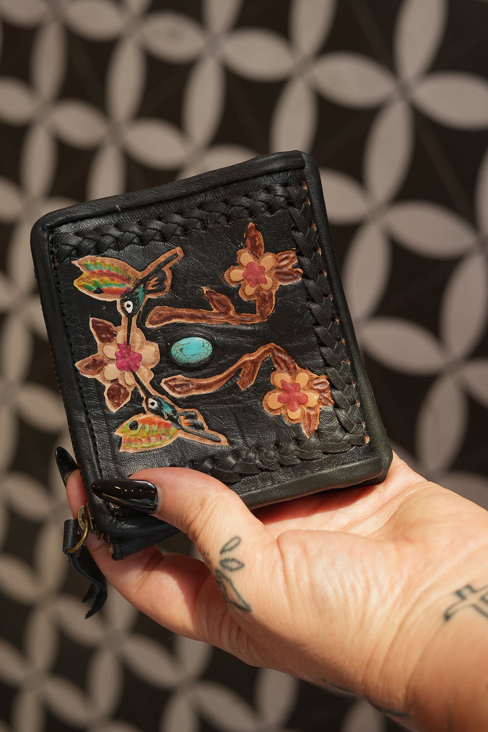 Meet the Freebird Mini Wallet in Midnight Black, a handcrafted leather wallet with colorful hummingbird artwork, turquoise accent and woven leather detailing.