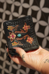 Meet the Freebird Mini Wallet in Midnight Black, a handcrafted leather wallet with colorful hummingbird artwork, turquoise accent and woven leather detailing.