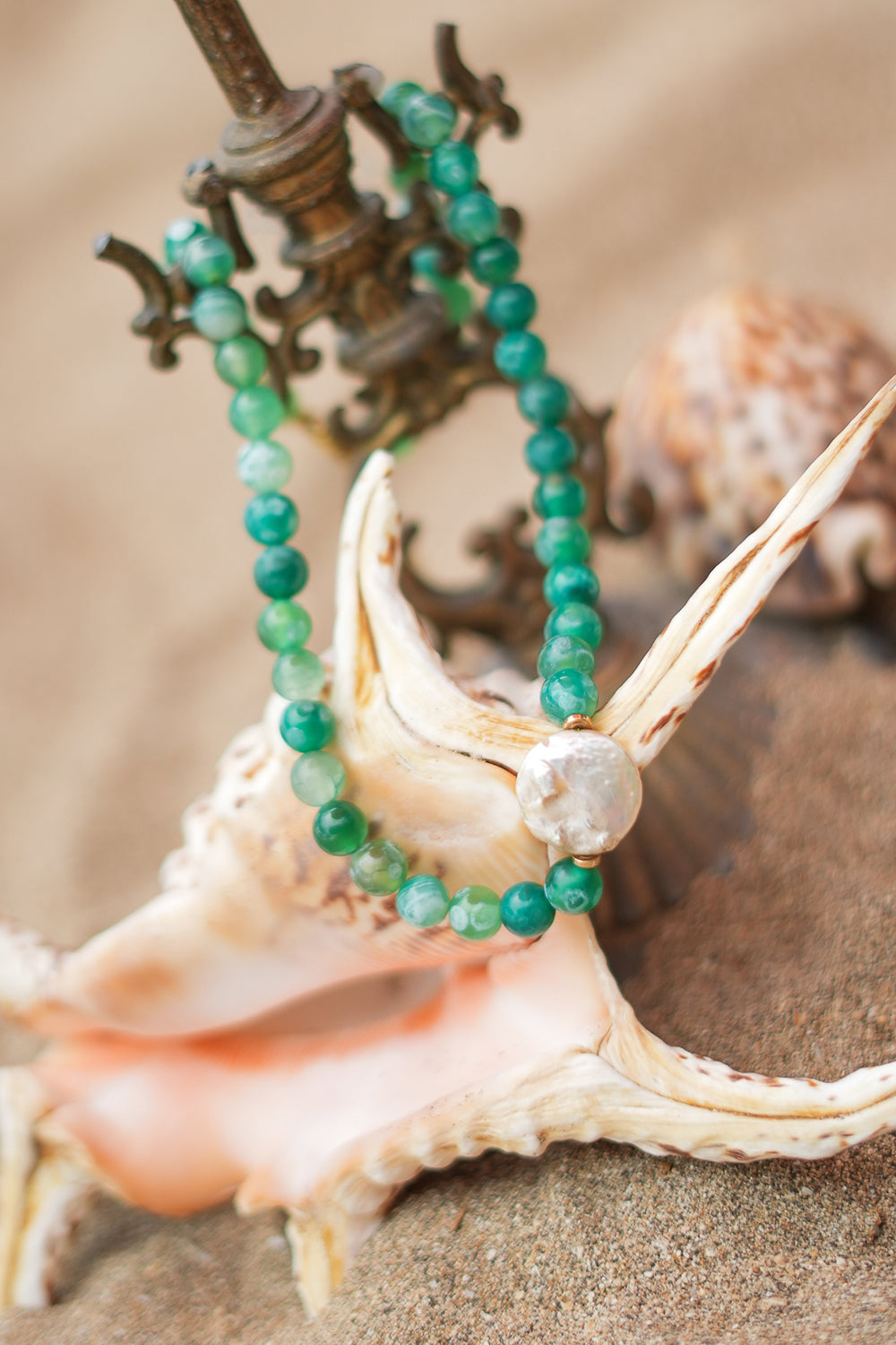 Shop the Gaia Pearl Necklace in Forest Agate, featuring green natural stone beads, an organic statement pearl and delicate gold toned details by Jinx the Label.