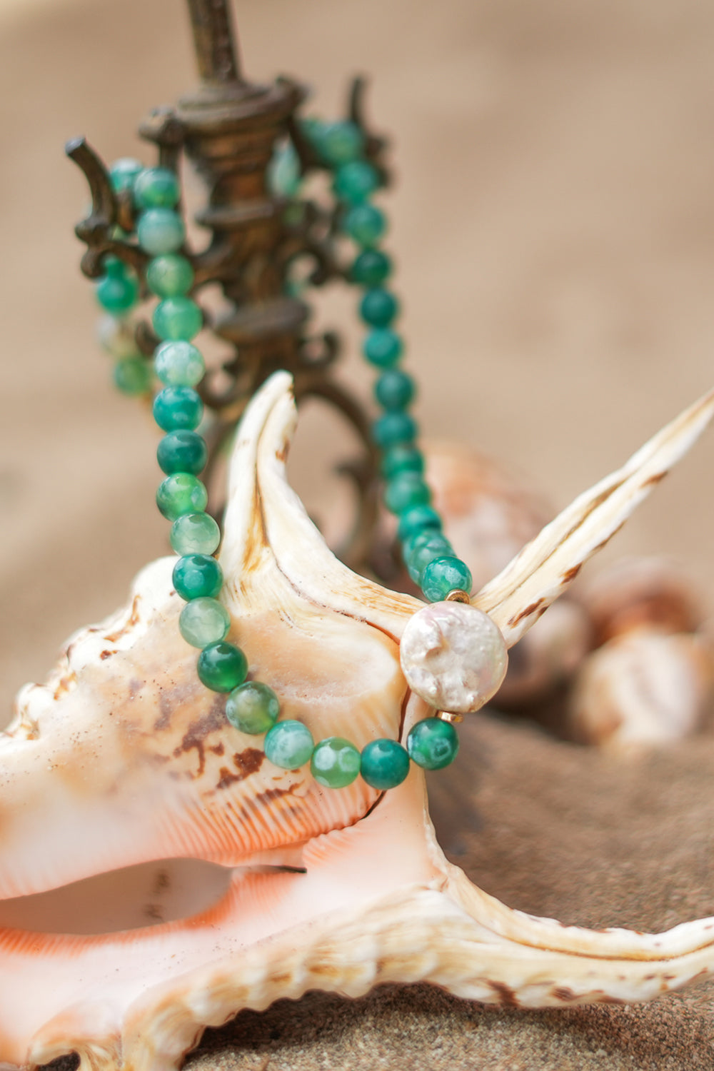 Shop the Gaia Pearl Necklace in Forest Agate, featuring green natural stone beads, an organic statement pearl and delicate gold toned details by Jinx the Label.