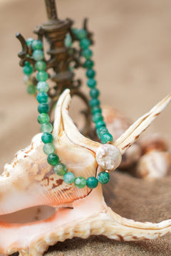 Shop the Gaia Pearl Necklace in Forest Agate, featuring green natural stone beads, an organic statement pearl and delicate gold toned details by Jinx the Label.