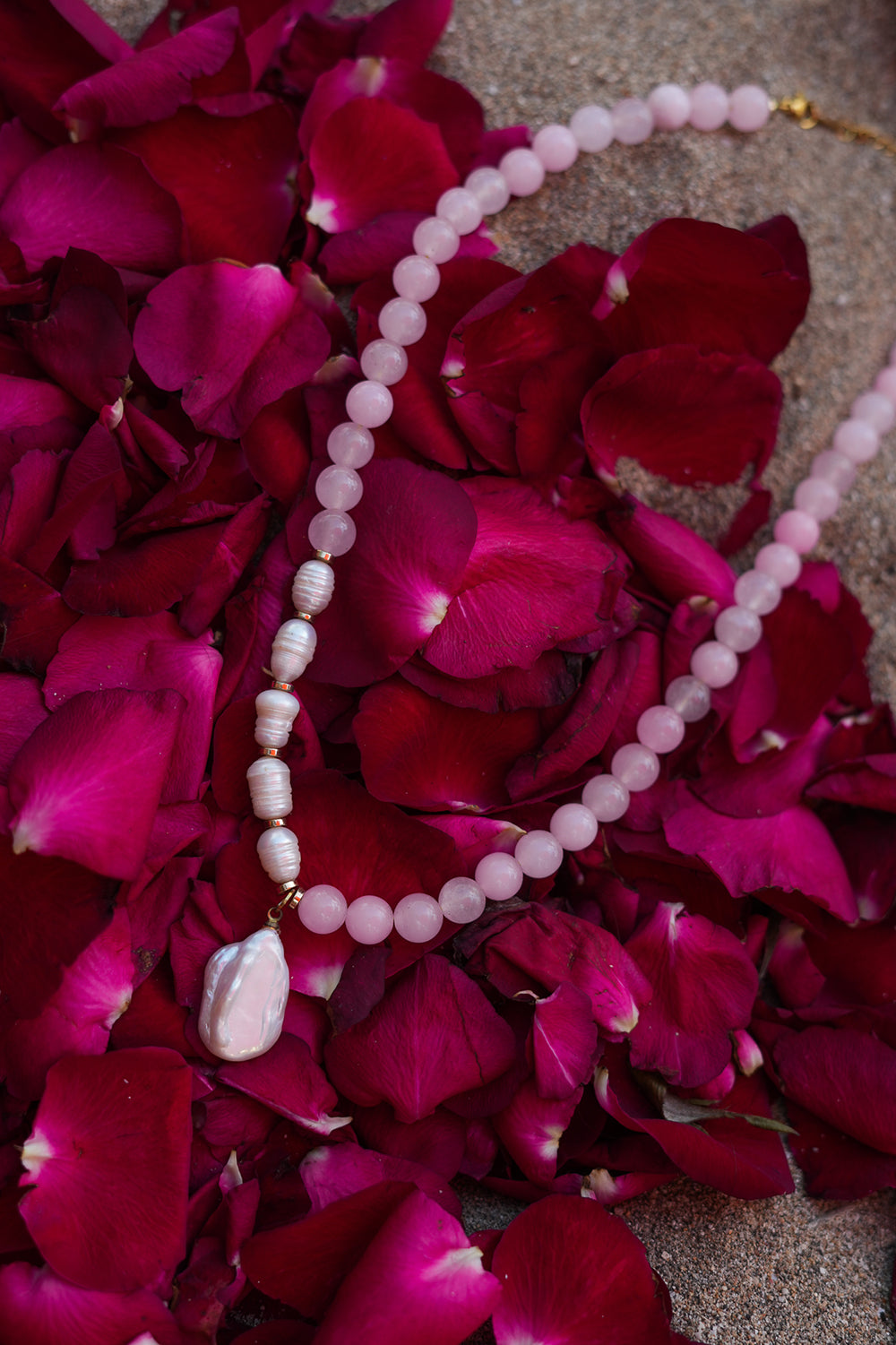 Discover the Love Spell Necklace in Rose Quartz, with blush natural stones, freshwater pearls, gold details and a baroque pearl pendant by Jinx the Label.