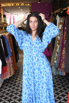 Meet the Magnolia Dress in Floral Blue, a flowing floral boho maxi with billowy sleeves, shell buttons, adjustable waist tie and pockets. Handmade in Bali.
