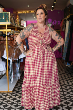 Meet the Mayana Maxi Dress in Wine Cream from Nevada. A dreamy rayon gingham maxi with shirring, adjustable front ties, a flowing ruffled skirt and pockets.