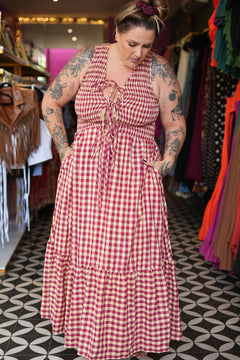 Meet the Mayana Maxi Dress in Wine Cream from Nevada. A dreamy rayon gingham maxi with shirring, adjustable front ties, a flowing ruffled skirt and pockets.