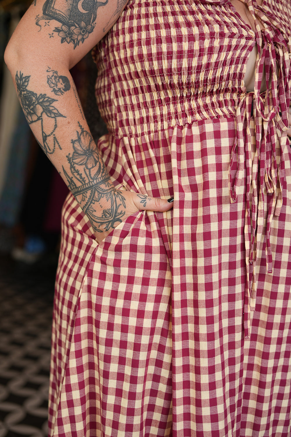Meet the Mayana Maxi Dress in Wine Cream from Nevada. A dreamy rayon gingham maxi with shirring, adjustable front ties, a flowing ruffled skirt and pockets.