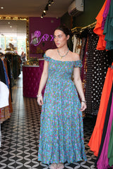 Meet the Mina Maxi Dress in Aqua Moon. A romantic rayon maxi with shirred bodice, off-shoulder ruffles, open tie back, pockets and flowing tiers.