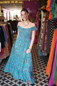 Meet the Mina Maxi Dress in Aqua Moon. A romantic rayon maxi with shirred bodice, off-shoulder ruffles, open tie back, pockets and flowing tiers.