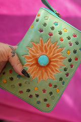 Meet the Mojave Wallet in Desert Mint. A hand tooled leather wallet with sunflower detailing, turquoise accents, card slots, coin compartment and wrist strap.