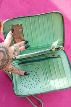Meet the Mojave Wallet in Desert Mint. A hand tooled leather wallet with sunflower detailing, turquoise accents, card slots, coin compartment and wrist strap.