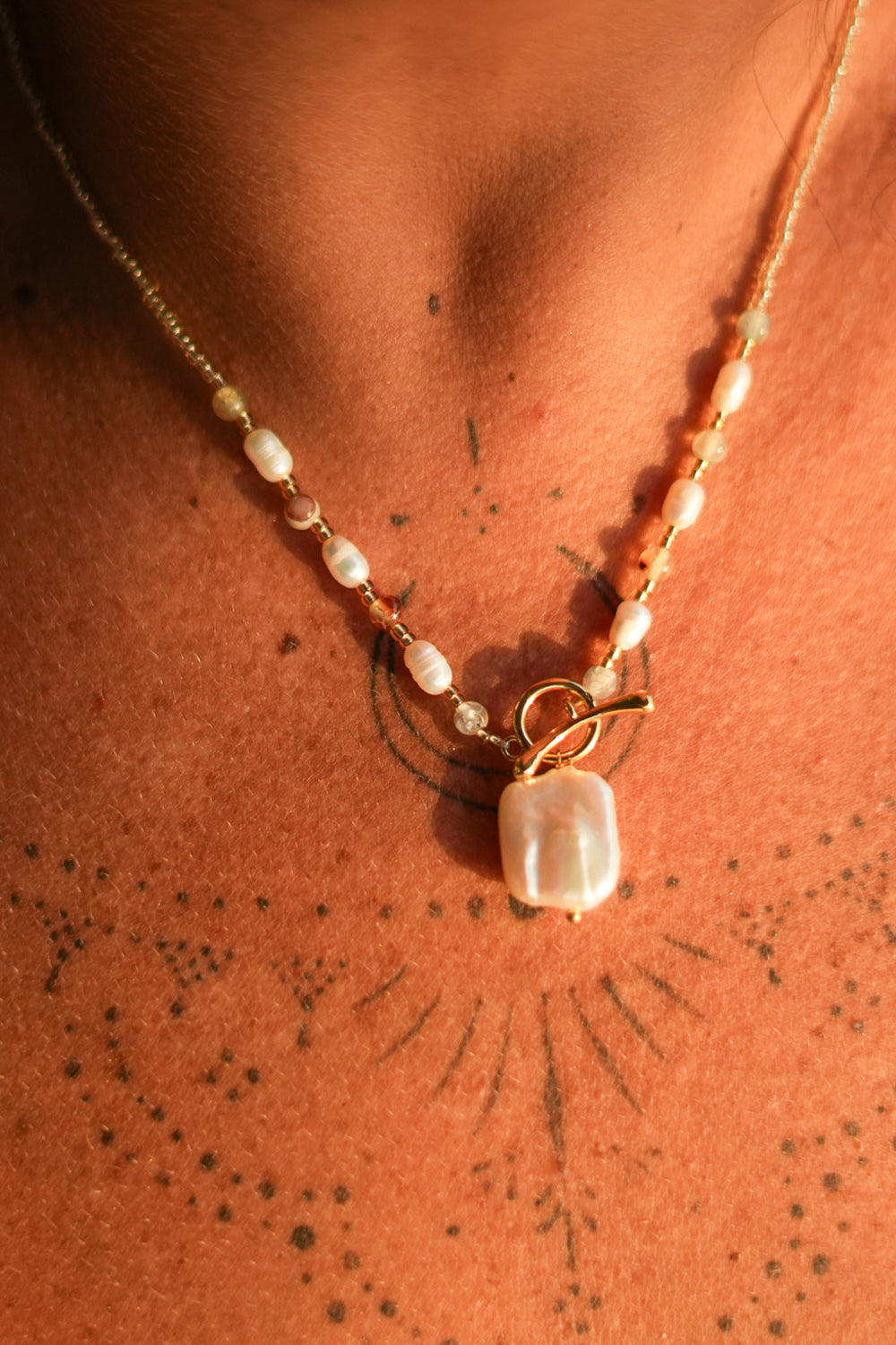 Shop the Moonwater Necklace in Pearl Gold, with delicate beads, organic pearls, gold toggle and a baroque pearl pendant from Earth Altering by Jinx the Label.
