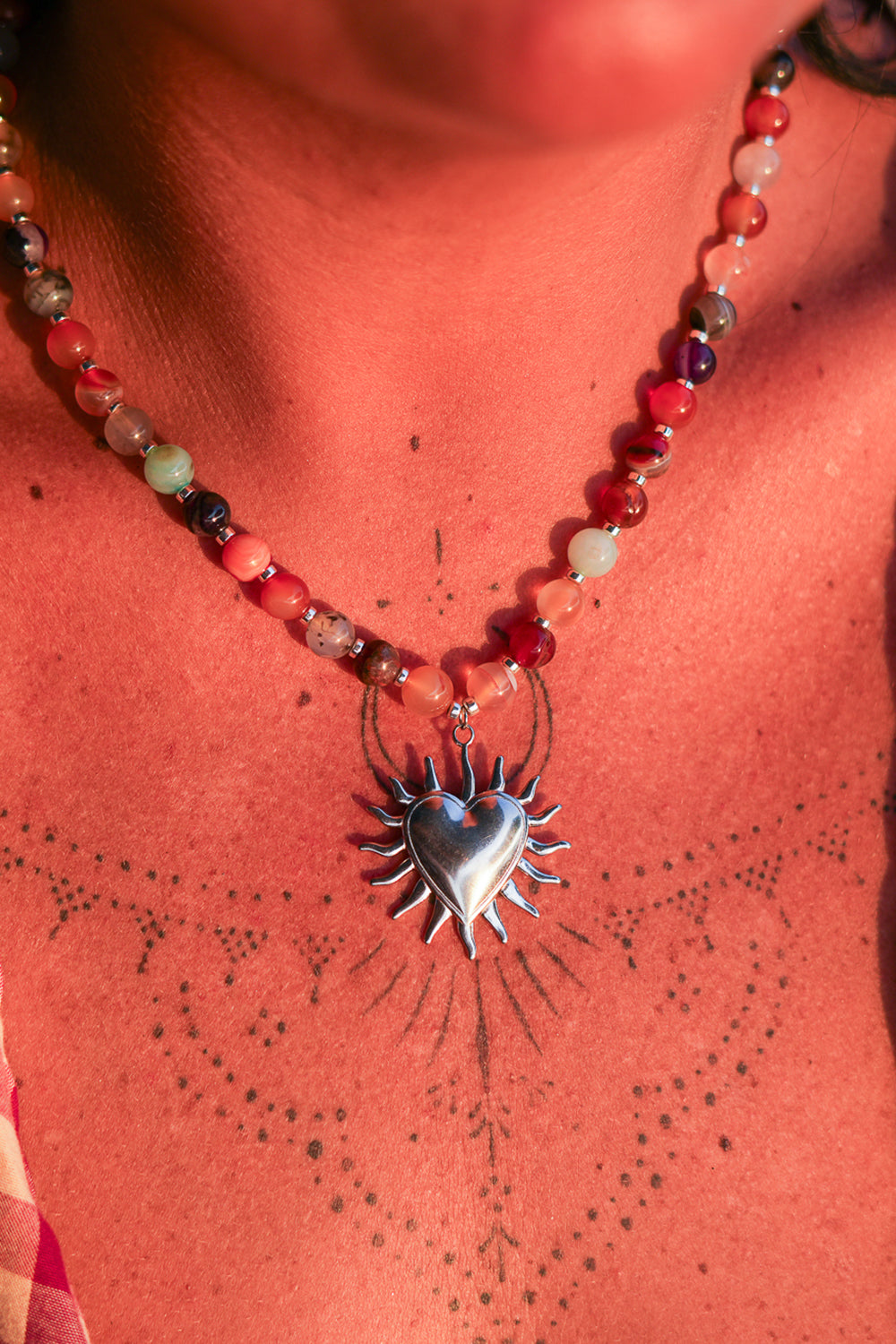 Meet the Sacred Flame Necklace in Wild Ember, with colorful natural stone beads and a statement silver heart pendant from Earth Altering by Jinx the Label.