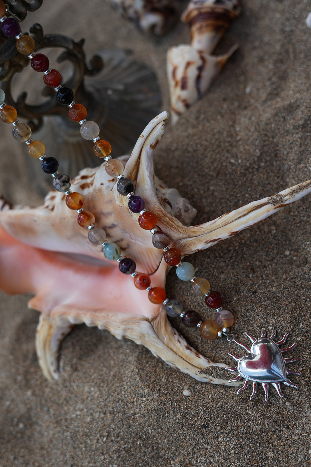 Meet the Sacred Flame Necklace in Wild Ember, with colorful natural stone beads and a statement silver heart pendant from Earth Altering by Jinx the Label.