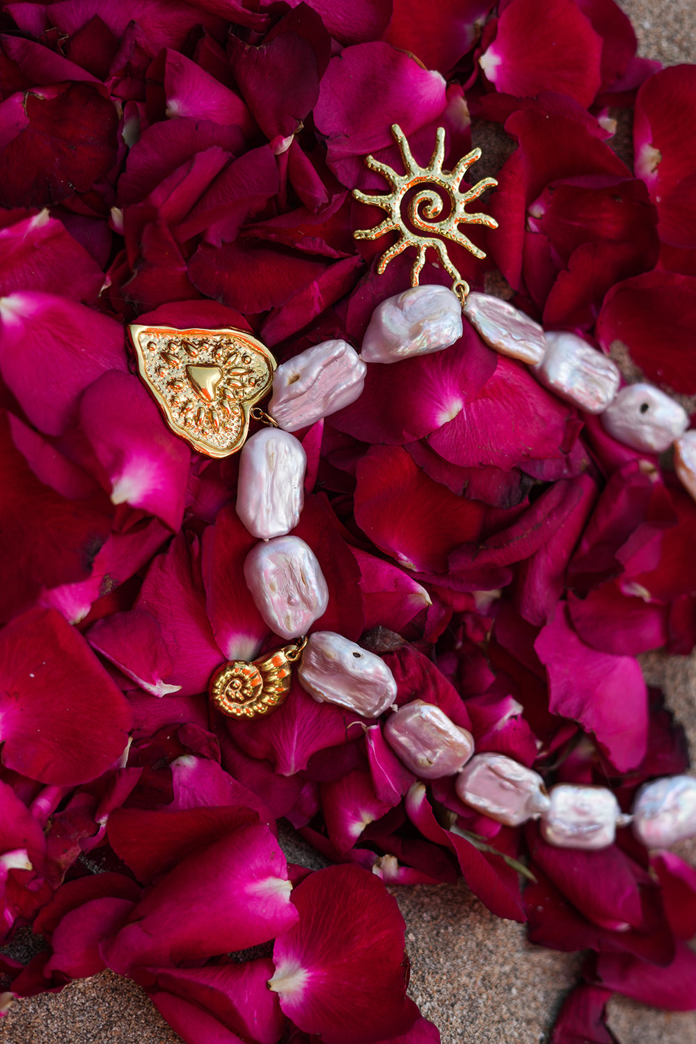 Discover the Sacred Love Necklace in Blush Pearl, featuring irregular freshwater pearls and gold sacred heart, sun and spiral charms by Jinx the Label.