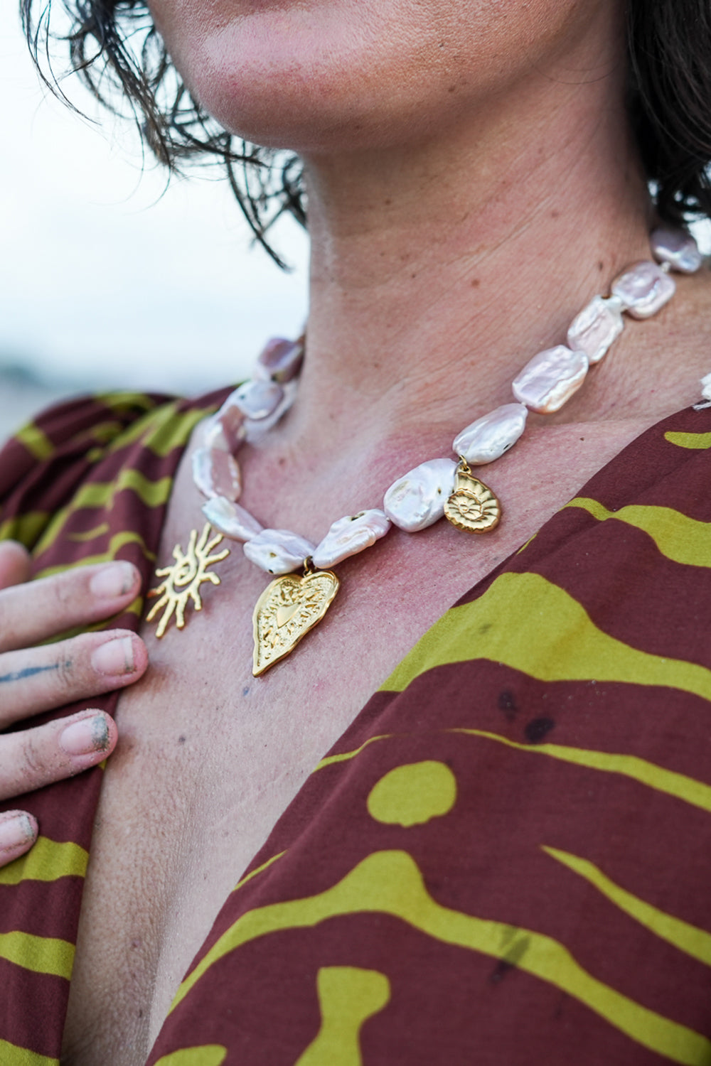 Discover the Sacred Love Necklace in Blush Pearl, featuring irregular freshwater pearls and gold sacred heart, sun and spiral charms by Jinx the Label.