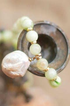 Discover the Sea Garden Necklace in Seafoam, featuring pale green natural stones, gold toned details and an oversized baroque pearl pendant by Jinx the Label.
