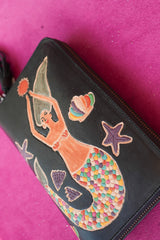Meet the Siren Wallet in Midnight Black. A handcrafted leather zip wallet with a hand painted mermaid, card slots, coin compartment, wrist strap and tassel.