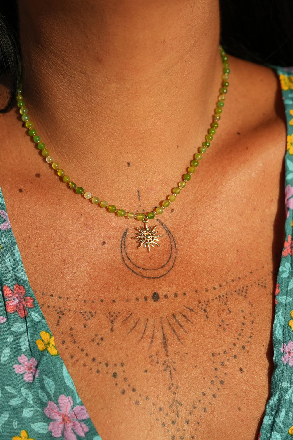 Shop the Solara Sun Necklace in Meadow Green, with natural green stone beads, a radiant gold sun charm and adjustable chain from Jinx the Label.
