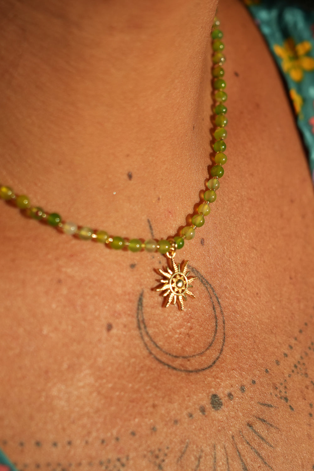 Shop the Solara Sun Necklace in Meadow Green, with natural green stone beads, a radiant gold sun charm and adjustable chain from Jinx the Label.