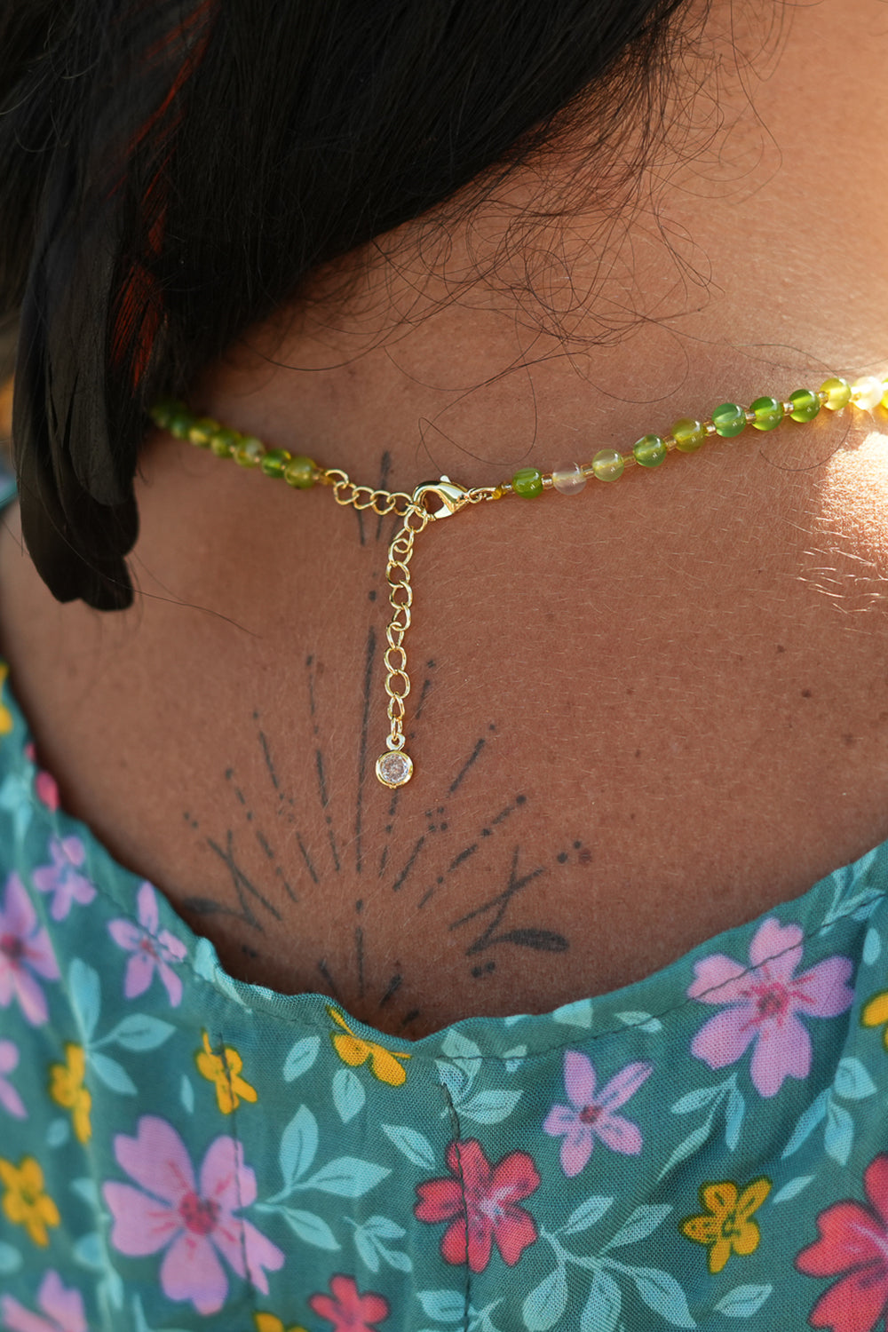 Shop the Solara Sun Necklace in Meadow Green, with natural green stone beads, a radiant gold sun charm and adjustable chain from Jinx the Label.