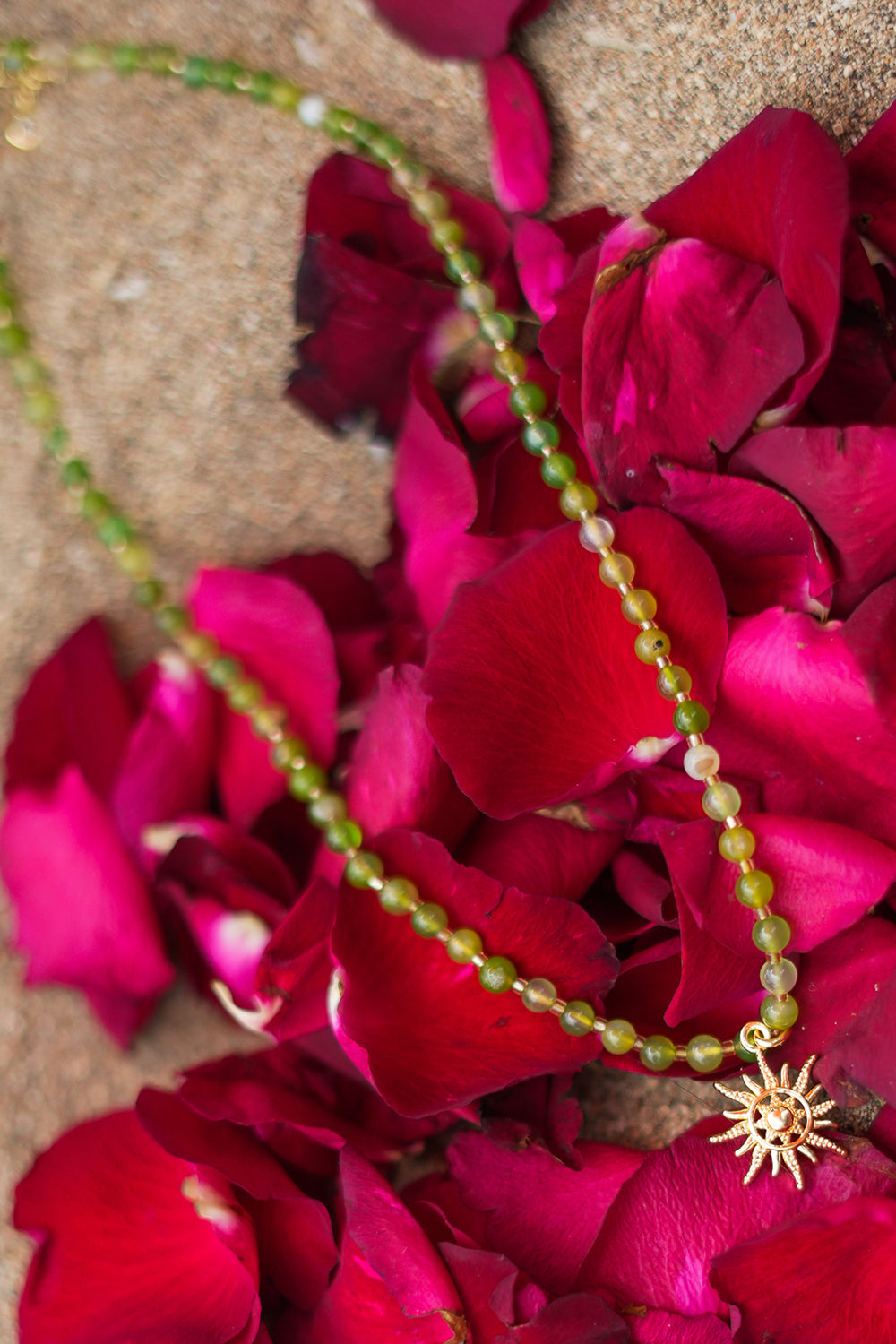 Shop the Solara Sun Necklace in Meadow Green, with natural green stone beads, a radiant gold sun charm and adjustable chain from Jinx the Label.