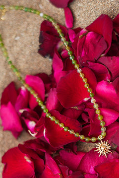 Shop the Solara Sun Necklace in Meadow Green, with natural green stone beads, a radiant gold sun charm and adjustable chain from Jinx the Label.