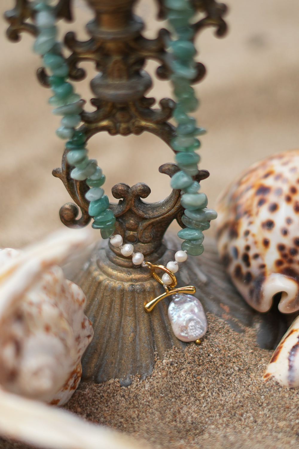 Discover the Tidal Earth Necklace in Amazonite, with natural green stone chips, freshwater pearls, gold toggle details and a baroque pearl by Jinx the Label.