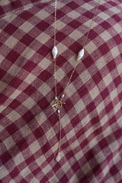 Shop the Tidal Lariat Necklace in Pearl Gold, featuring organic baroque pearls, fine gold chain and an elegant drop from Earth Altering by Jinx the Label.