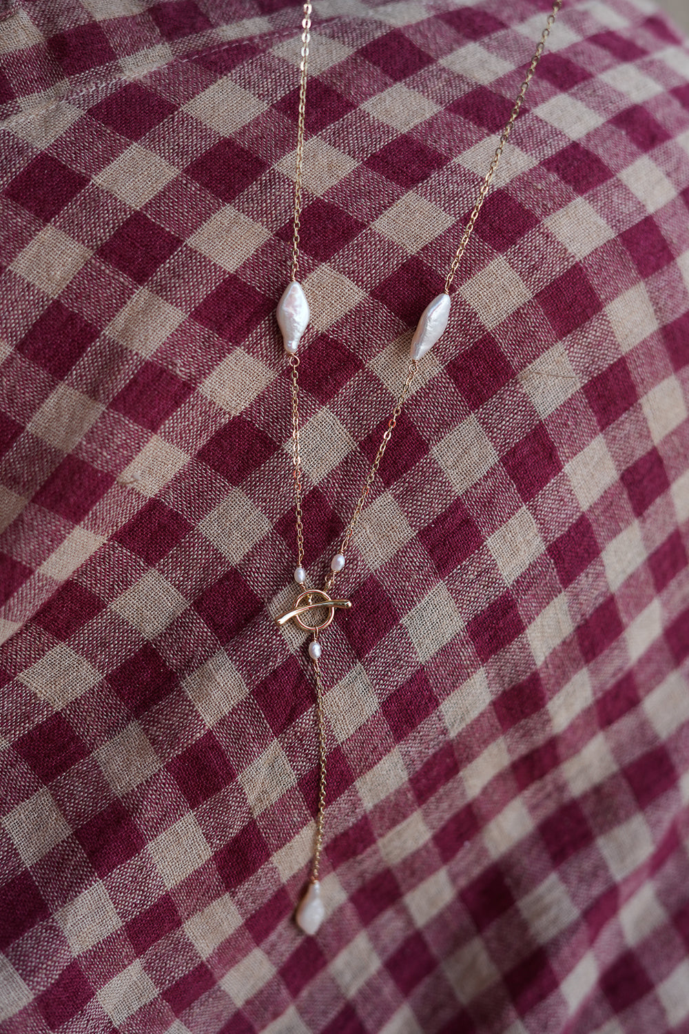 Shop the Tidal Lariat Necklace in Pearl Gold, featuring organic baroque pearls, fine gold chain and an elegant drop from Earth Altering by Jinx the Label.