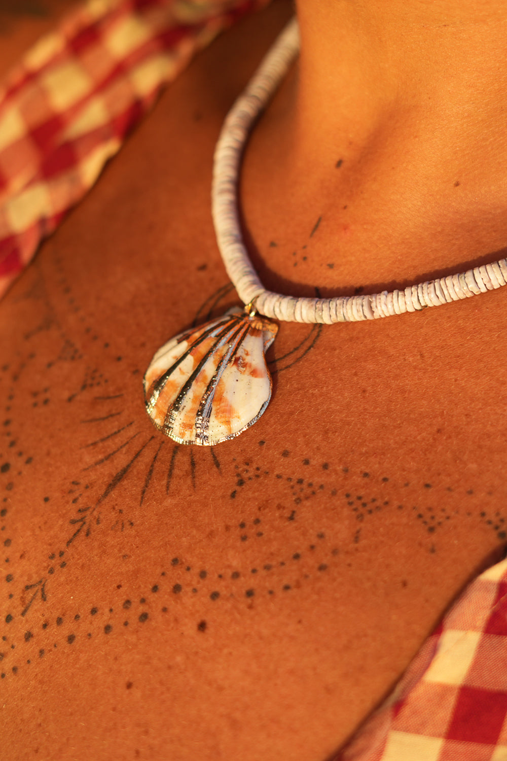 Shop the Tidal Treasure Necklace in Sunbleached Shell, featuring natural shell beads and a gold detailed shell pendant from Earth Altering by Jinx.