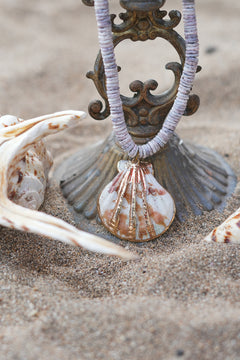 Shop the Tidal Treasure Necklace in Sunbleached Shell, featuring natural shell beads and a gold detailed shell pendant from Earth Altering by Jinx.