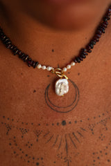 Discover the Wild Heart Necklace in Garnet, featuring deep natural garnet stones, freshwater pearls, a gold toggle and luminous baroque pearl by Jinx the Label.