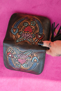 Meet the Wildheart Wallet in Burnished Espresso. A handcrafted leather zip wallet with hand tooled motives, card slots, a coin compartment and leather tassel.