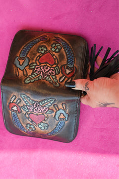 Meet the Wildheart Wallet in Burnished Espresso. A handcrafted leather zip wallet with hand tooled motives, card slots, a coin compartment and leather tassel.